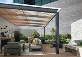 An outdoor patio with a wooden pergola, seating area, and a fire feature.