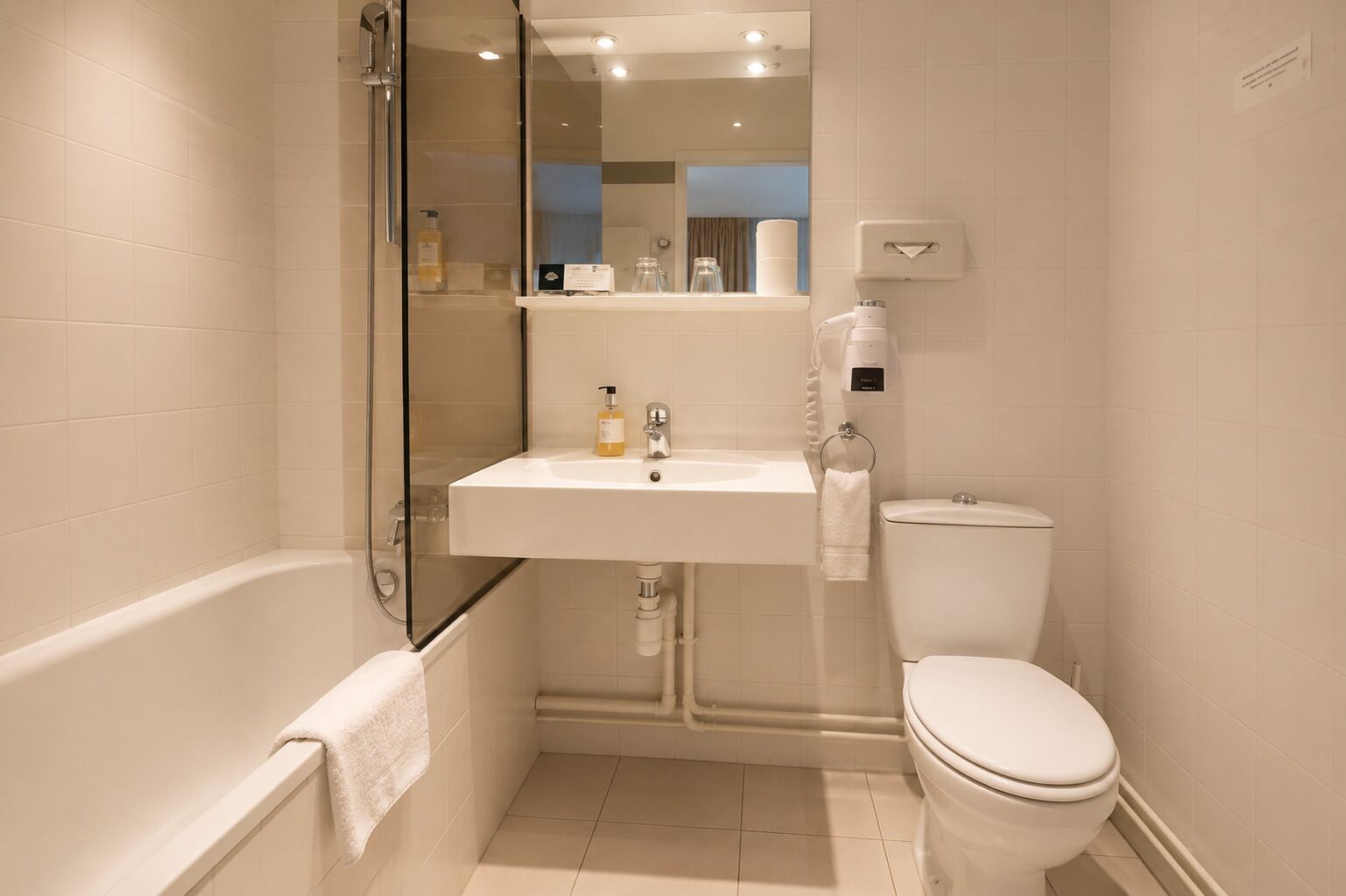 A bathroom with a bathtub, a sink, a toilet, and a glass shower enclosure.