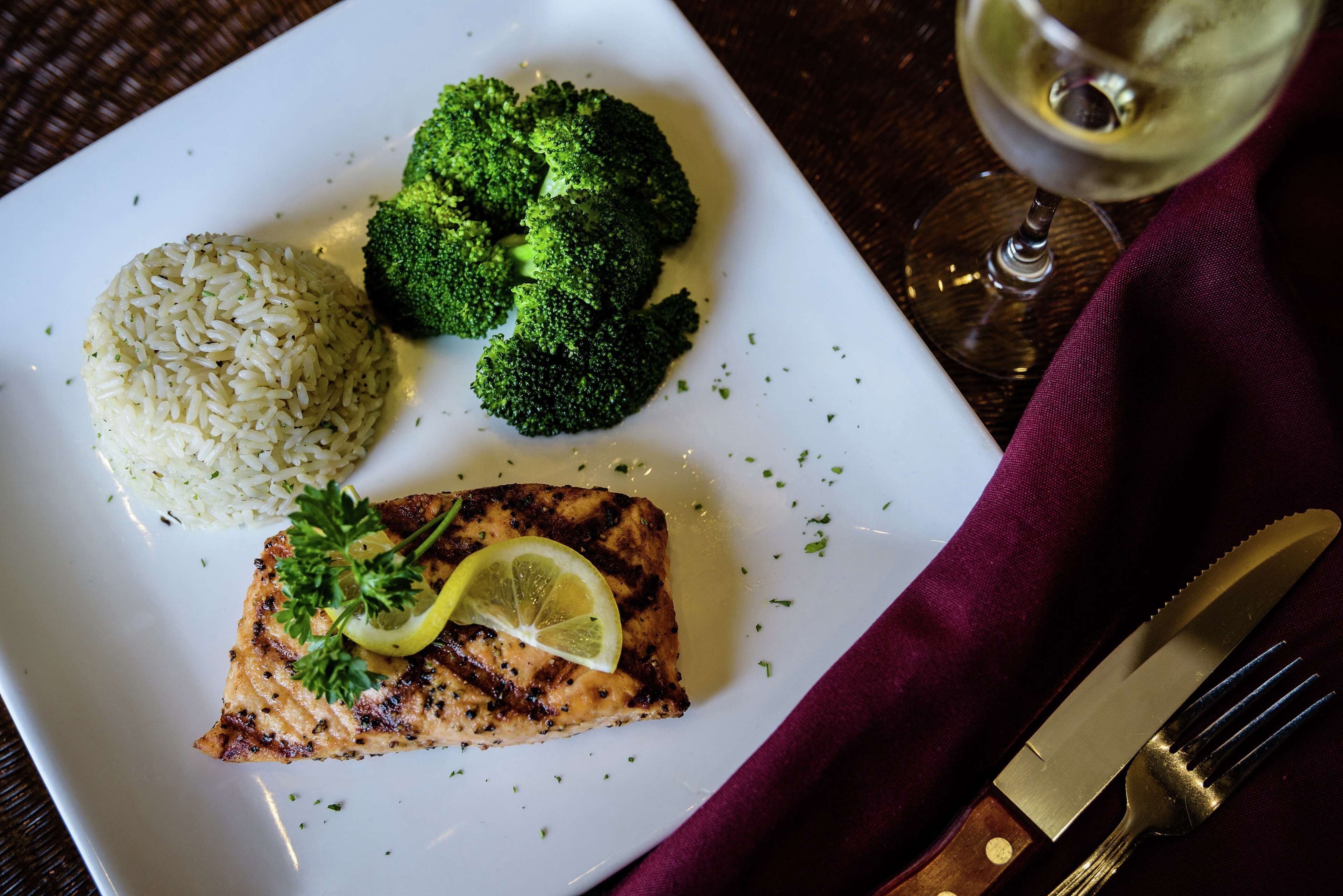 A plate with grilled salmon, broccoli, and rice.