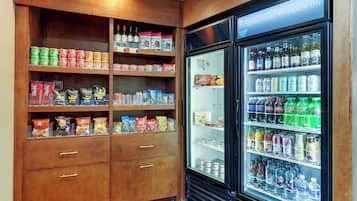 Un distributeur automatique rempli d’en-cas et de boissons, ainsi qu’un meuble en bois contenant divers produits alimentaires.