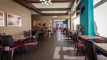 A spacious restaurant with high ceilings, modern lighting, and a mix of seating arrangements.