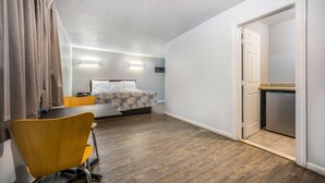 A hotel room with a bed, a desk, a chair, and a door leading to a bathroom. - Motel 6 Toms River, NJ - Near Seaside Heights (Toms River)