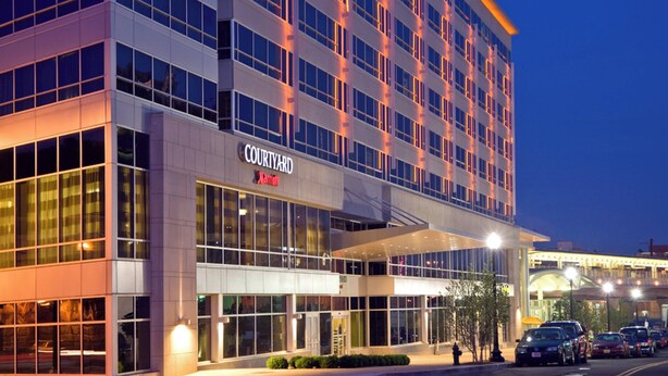 Un hotel Courtyard Marriott con fachada moderna, ventanas grandes y zona de acceso cubierta.