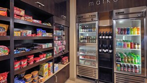 Un supermercado con estantes llenos de bocadillos, bebidas y secciones refrigeradas.