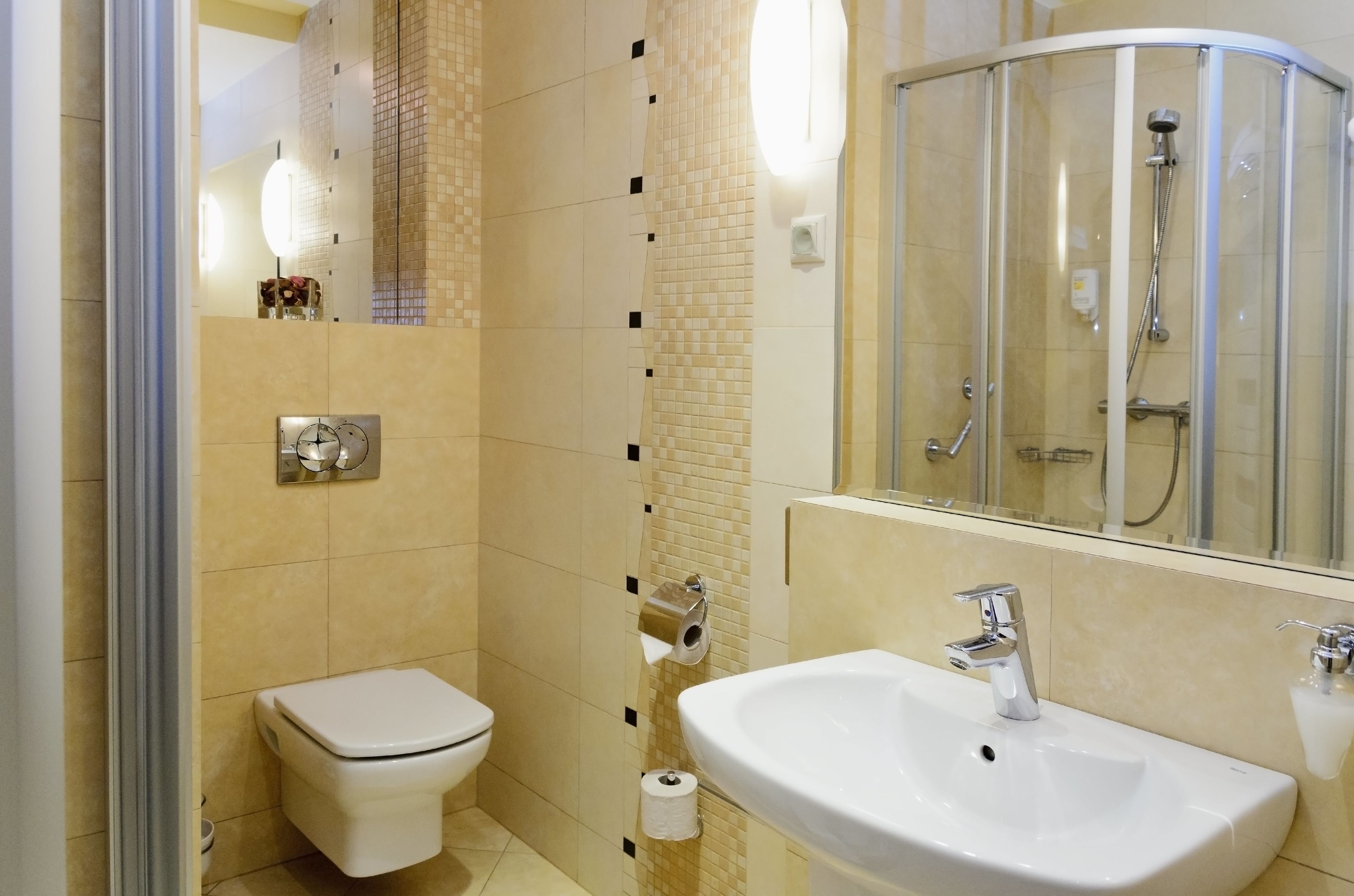 A modern bathroom with a toilet, sink, and glass-enclosed shower.