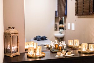 Un mostrador de baño con velas, un espejo y artículos de aseo.