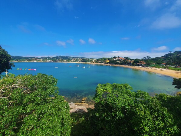 A coastal view with clear waters, boats, and a beach. - Insolito Boutique Hotel (Búzios)