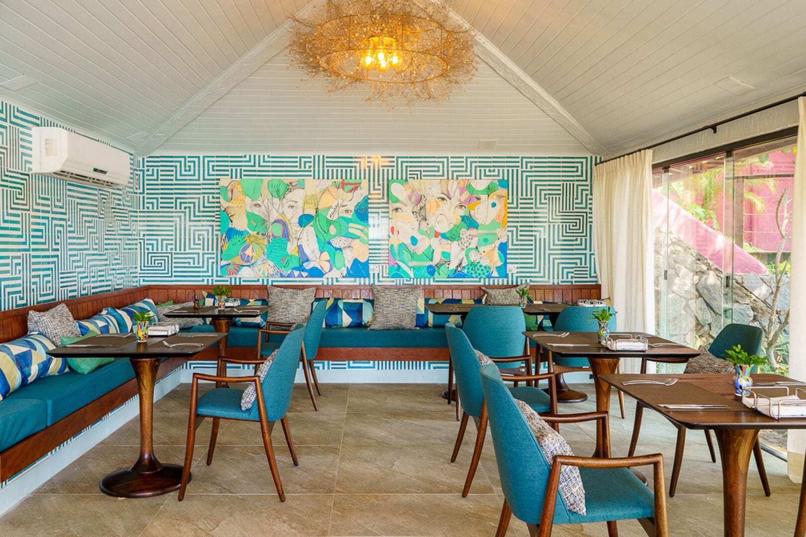 A restaurant with a high ceiling, patterned walls, and a central seating area with a large mural.