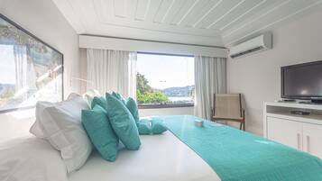 Una camera d'albergo con un letto, una televisione, una scrivania e una finestra con tende.