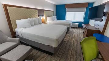 A hotel room with two beds, a TV, a desk, and a chair.
