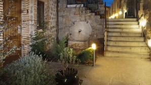 Un edificio de piedra con una escalera que sube a un nivel superior.