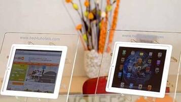 Two tablets displaying hotel websites, placed on stands with clear signage.