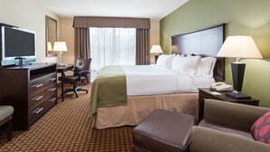 Een hotelkamer met een bed, bureau, stoel en televisie.