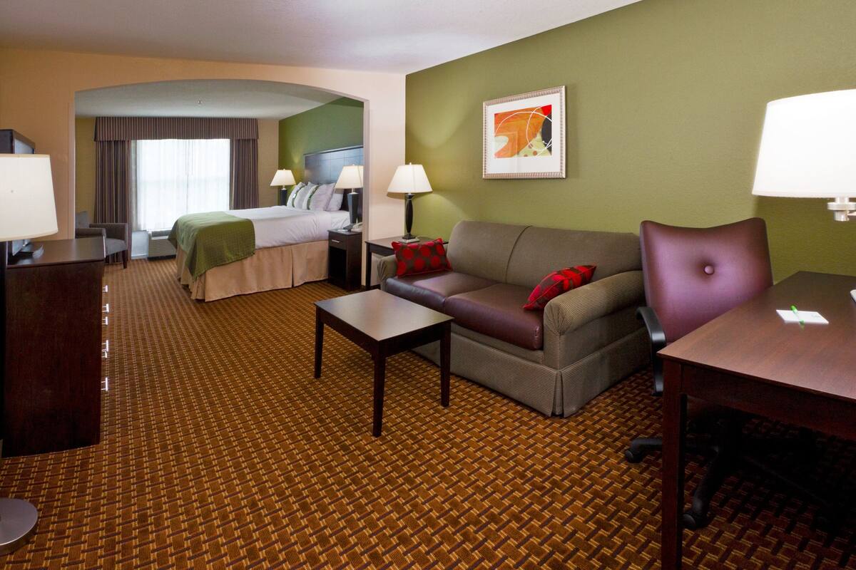 Ein Hotelzimmer mit Bett, Sofa, Schreibtisch und Stuhl.