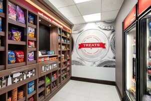 A snack display area with various packaged snacks and a wall with a circular design labeled "TREATS".