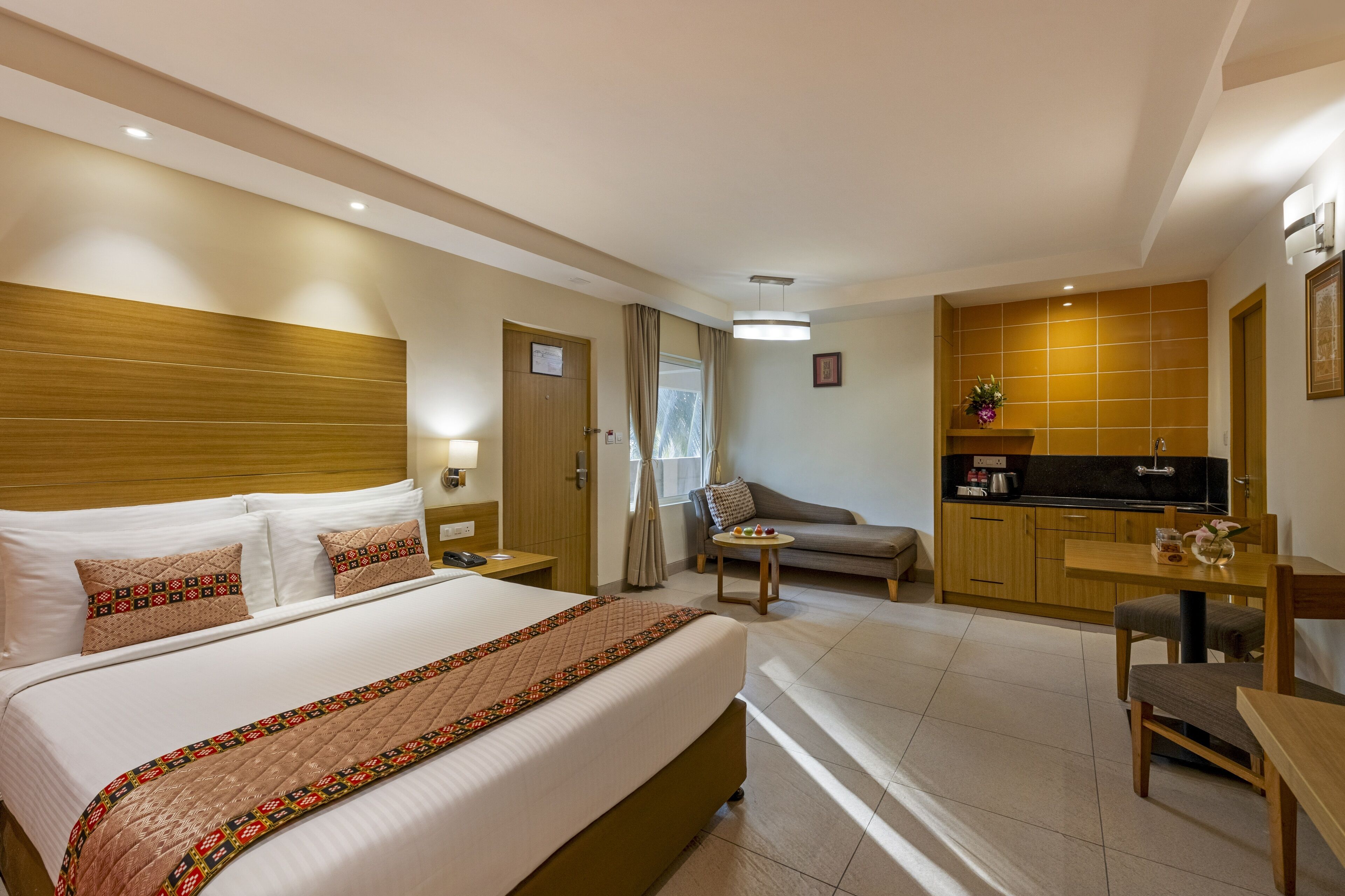 Una camera d'albergo con un letto grande, un angolo cottura, un divano e un tavolo da pranzo.