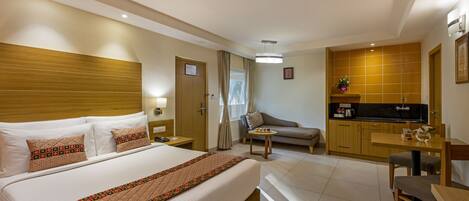 Una camera d'albergo con un letto grande, un angolo cottura, un divano e un tavolo da pranzo.