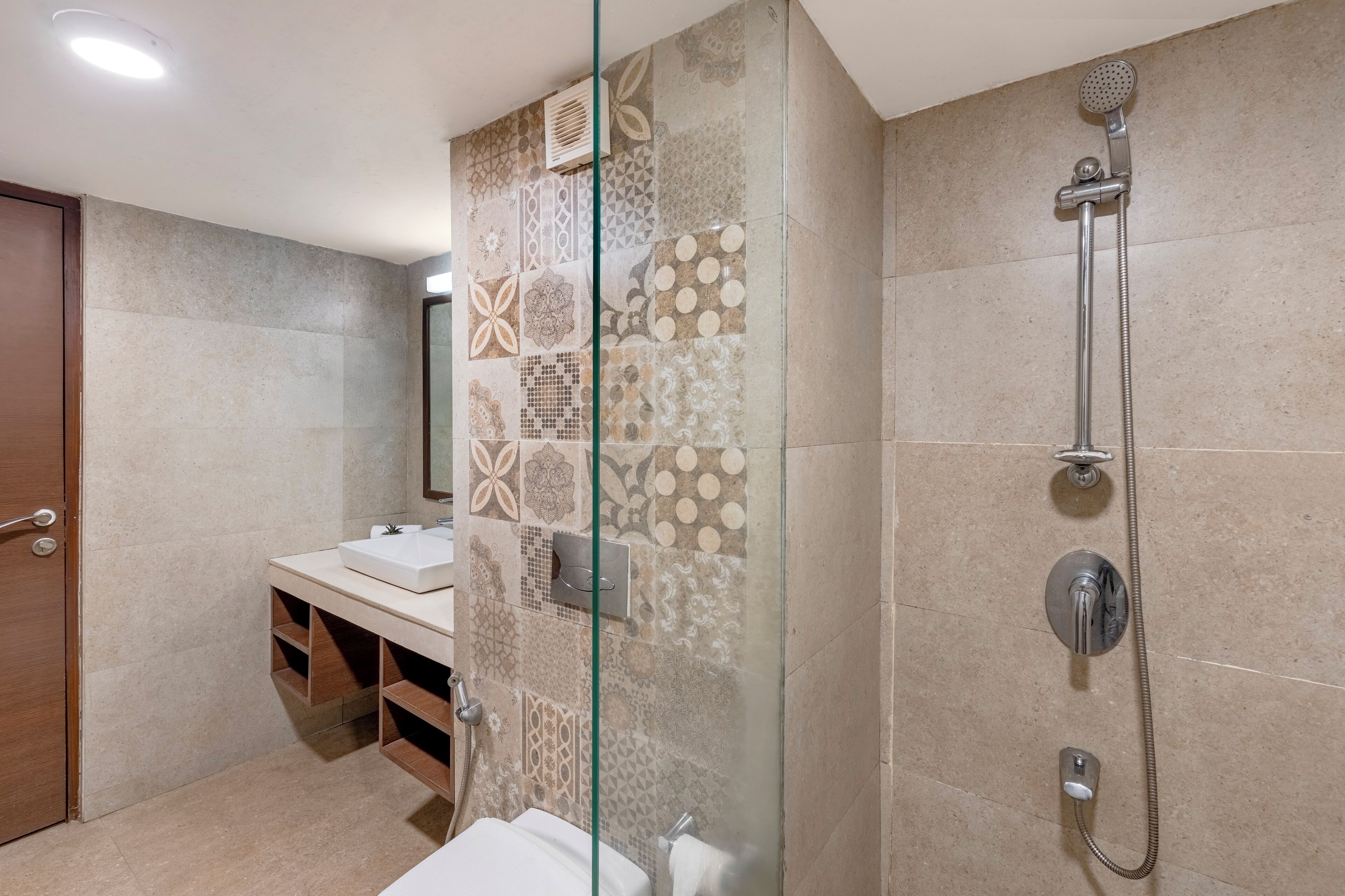 A modern bathroom with a glass shower enclosure, a sink, and a toilet.
