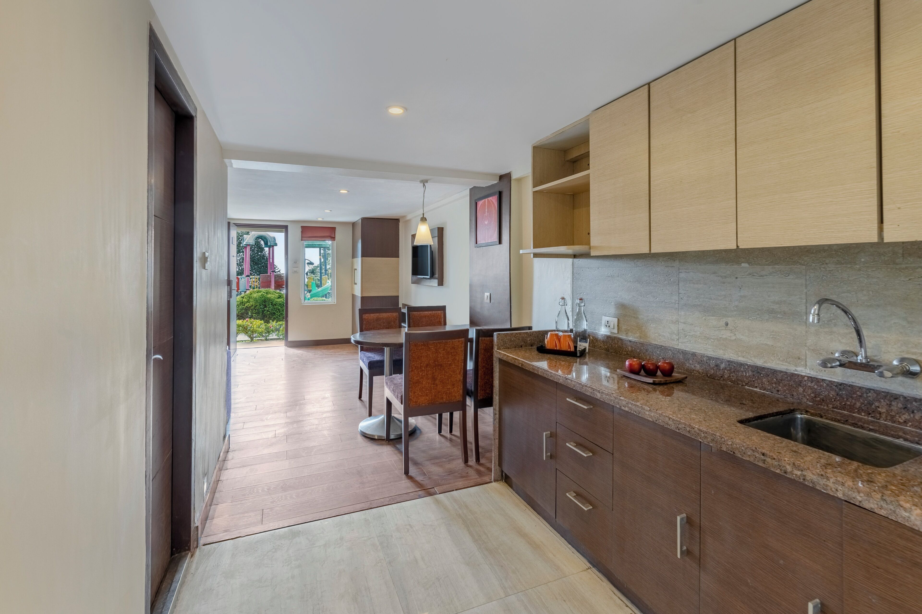 A modern kitchen with wooden cabinets, a granite countertop, and a stainless steel sink.
