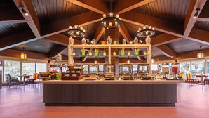 A spacious dining area with a central island, wooden ceiling beams, and pendant lighting. - Sterling Darjeeling (Darjeeling)