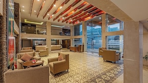 A spacious lobby with a patterned floor, comfortable seating, and large windows offering a view of the outside. - Sterling Darjeeling (Darjeeling)