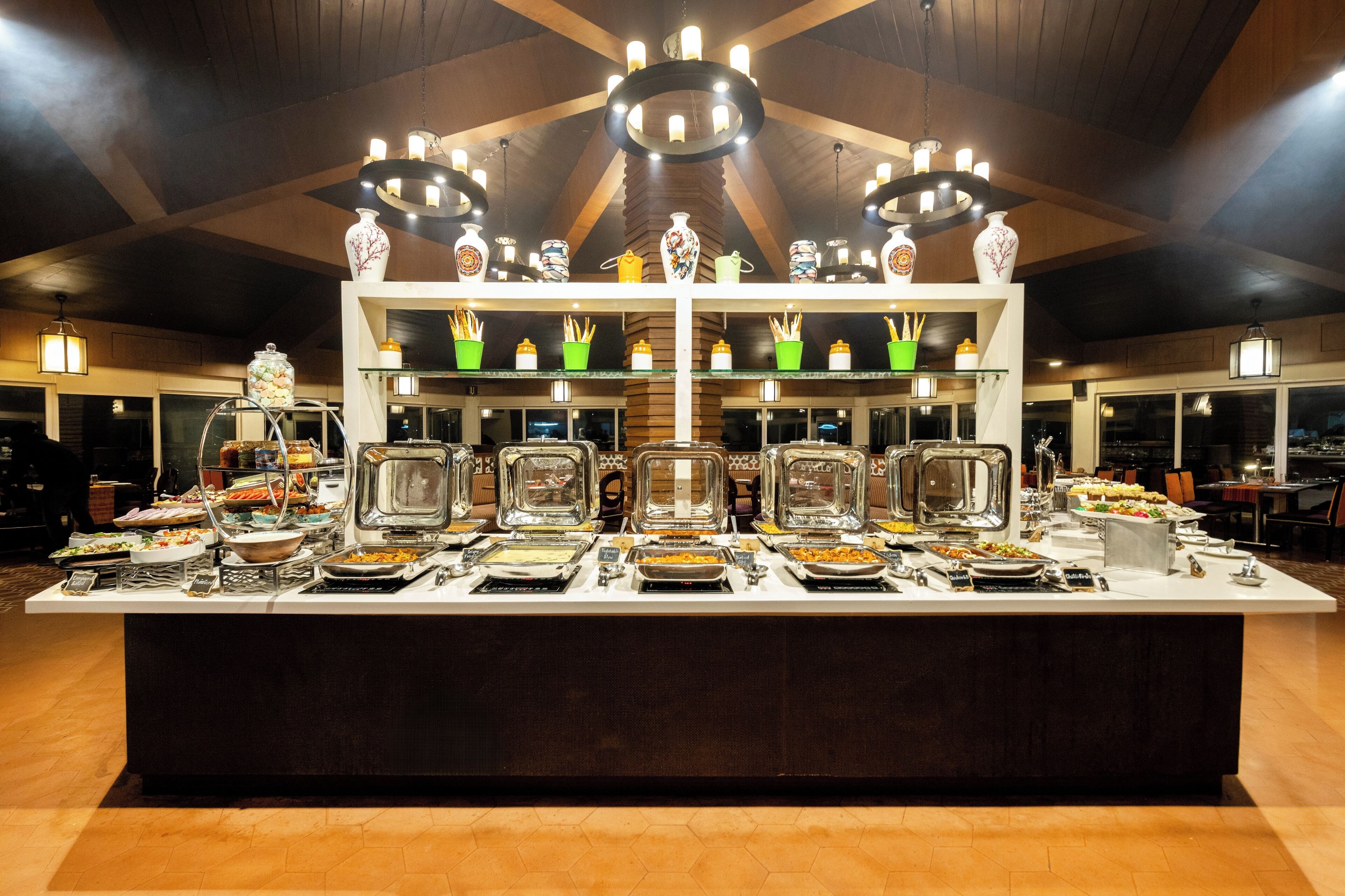 A buffet with various food items and decorative vases on shelves.