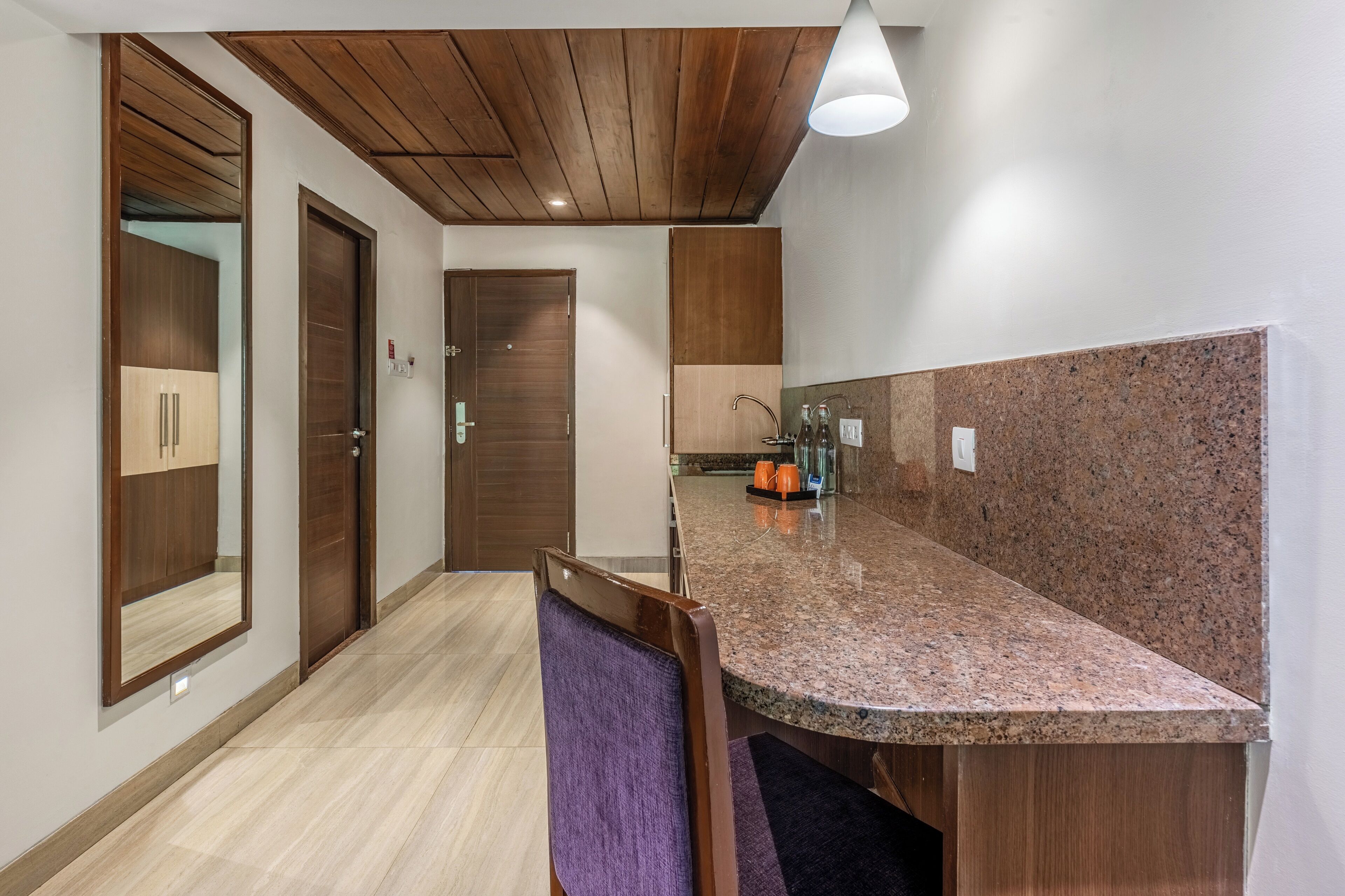 A modern kitchen with granite countertops, wooden cabinets, and a built-in oven.