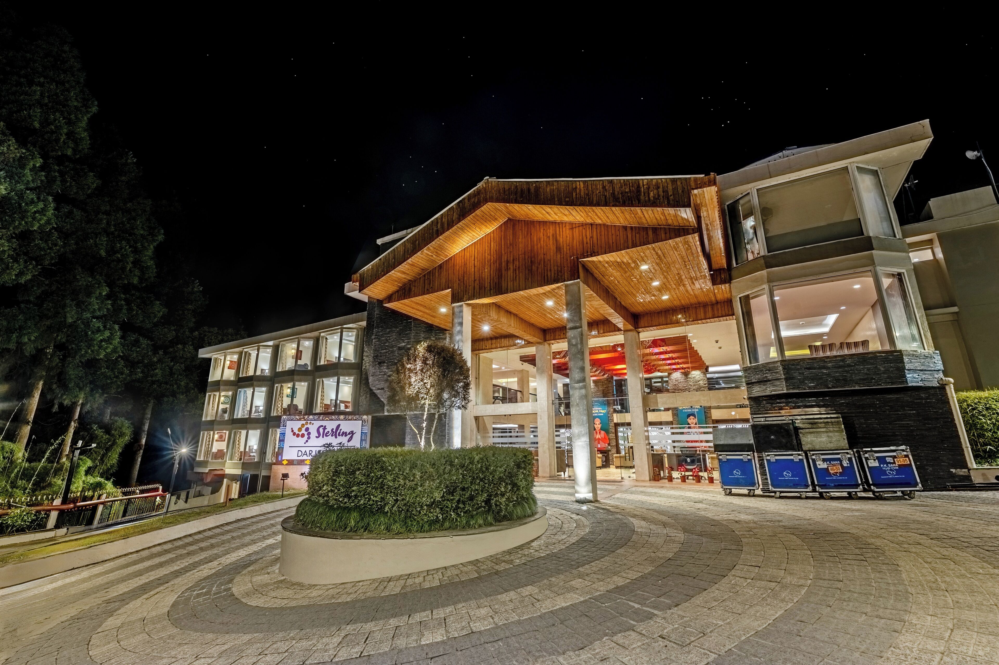 A modern hotel with a prominent wooden facade, large windows, and a well-lit entrance area.