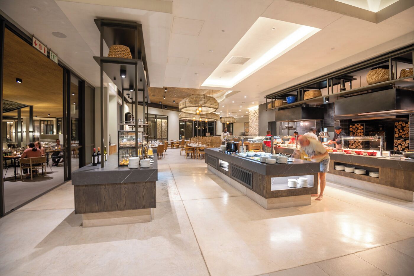 Een modern restaurant met een centraal aanrecht, een eethoek en een zichtbare keuken.
