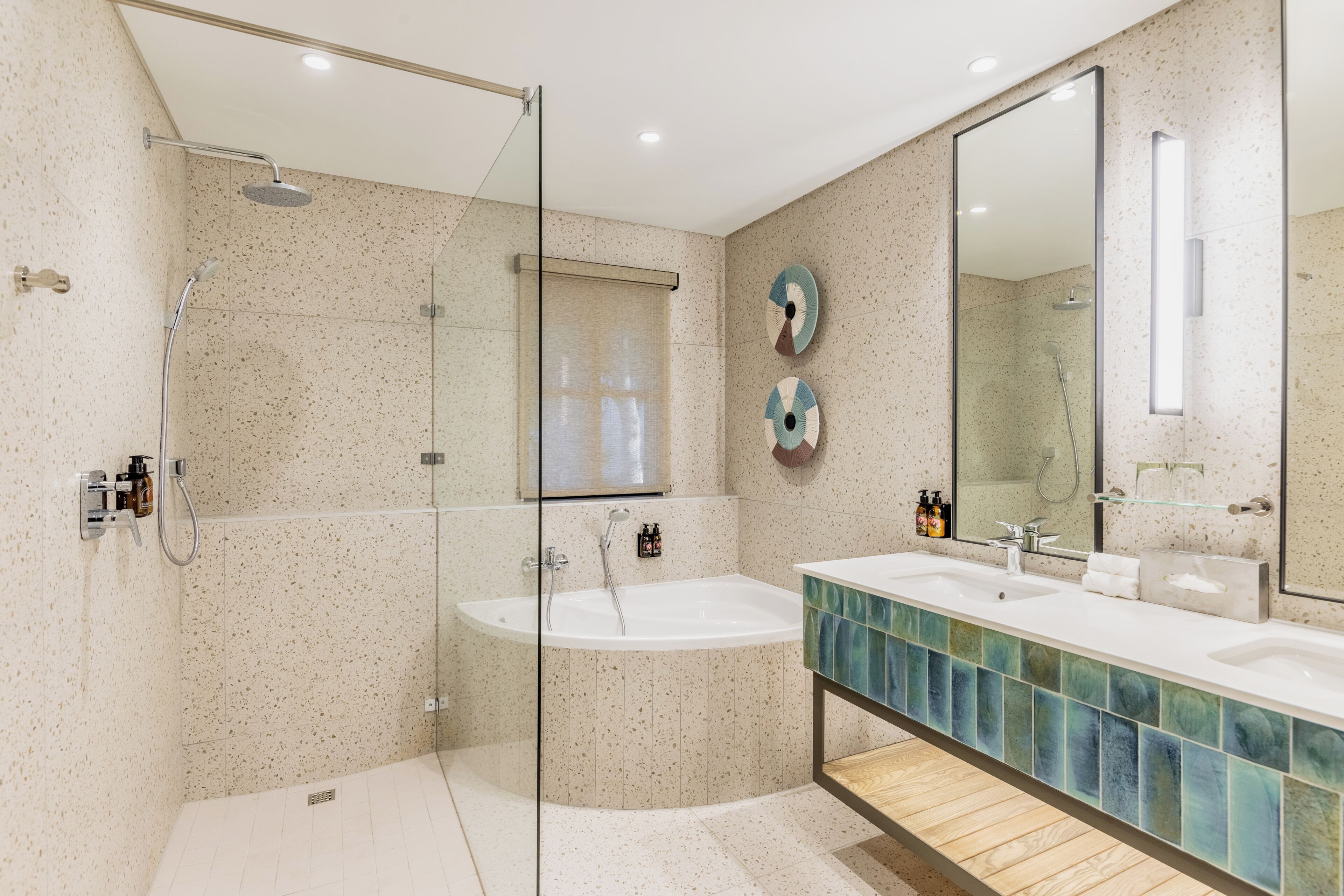 A modern bathroom with a glass-enclosed shower, a freestanding bathtub, and a vanity with a mirror.
