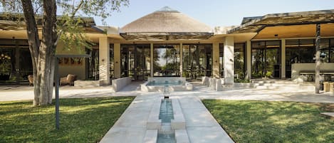 A modern building with a central water feature, large glass windows, and a symmetrical design.