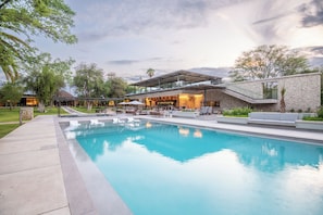 Un hotel moderno con piscina, zona de estar al aire libre y restaurante.