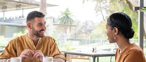 Una mesa de comedor con platos de comida, un salero y una taza de café.