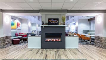 A modern lounge area with a fireplace, seating, and artwork.