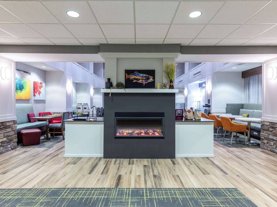 A modern lounge area with a fireplace, seating, and artwork.