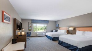A hotel room with two beds, a desk, a chair, a TV, and a window with a view of greenery. - Hampton Inn & Suites Casper (Casper)