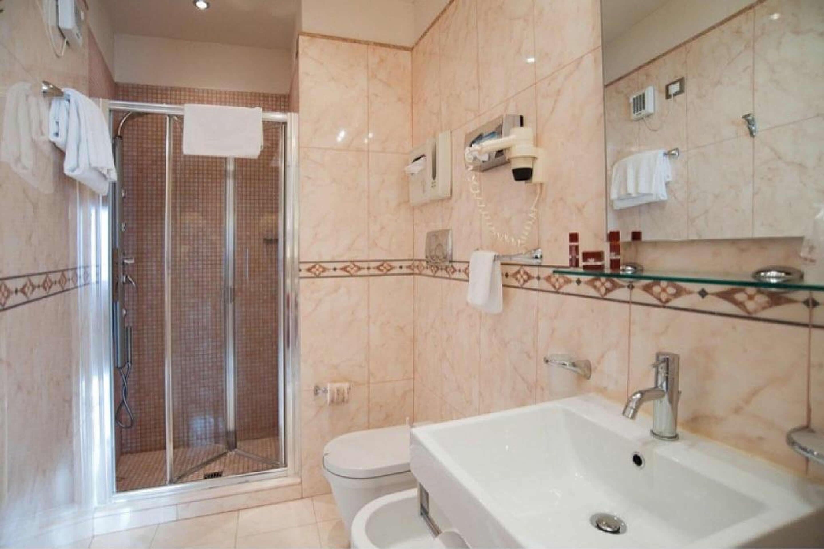 Un baño con cabina de ducha de vidrio, un lavabo blanco y un inodoro.