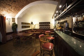 A cozy restaurant with a brick ceiling, wooden furniture, and a bar area.