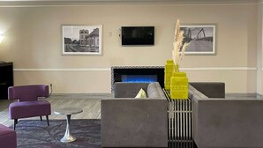 Una zona d'estar moderna amb una llar de foc, seients còmodes i obres d'art a les parets.