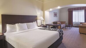 Habitació d'hotel amb un llit gran, un escriptori, una cadira i un sofà.