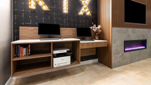 A reception desk with two monitors, a printer, and a wall-mounted TV.