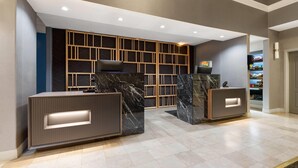 A reception area with marble counters, recessed lighting, and a modern design.