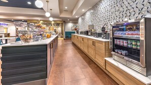 Un moderno comedor para desayunos con servicio de buffet, una cafetera y un refrigerador con productos lácteos.
