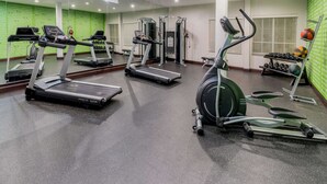 A gym with treadmills, elliptical machines, and free weights.