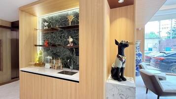 A modern kitchen with built-in shelves, a marble countertop, and a decorative dog statue.