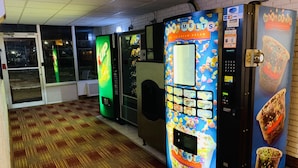 A row of ice cream vending machines with a digital display and payment options. - Countryside Suites Kansas City Independence I-70E Sports Complex Hotel (Independence)