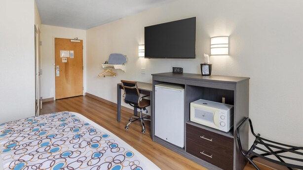 A hotel room with a bed, a desk with a computer, a microwave, and a chair. - SureStay Plus Hotel by Best Western Niagara Falls East (Niagara Falls)