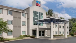 Un hotel de varios pisos con entrada cubierta y un letrero que indica que es un SureStay.