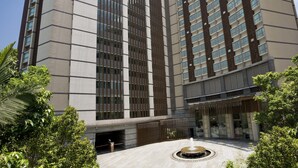 A modern hotel with a central courtyard, a fountain, and a large entrance with a covered area. - Royal View Hotel (Tsuen Wan)