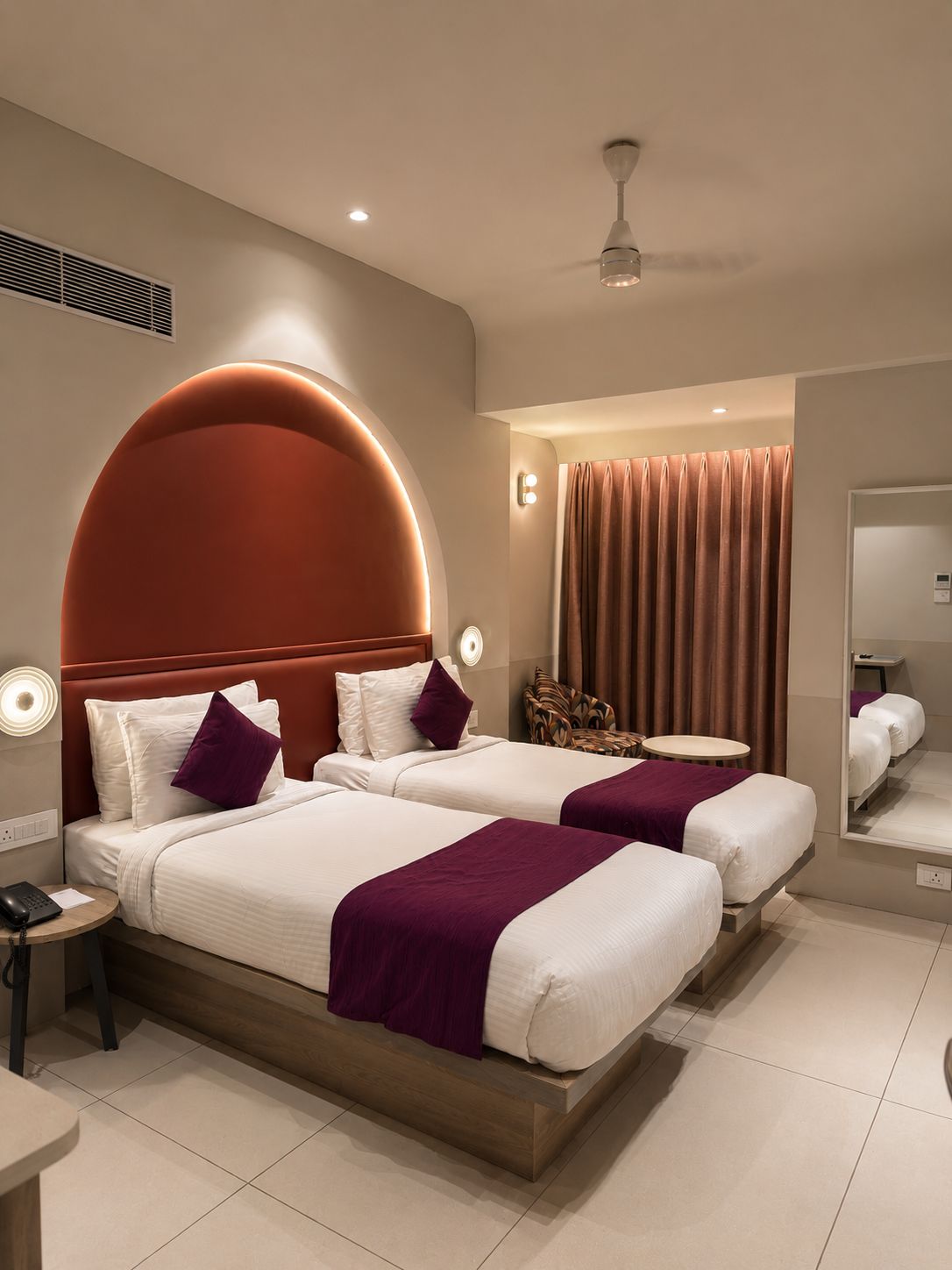 A hotel room with a large bed, a bedside table, a chair, a round table, and a ceiling fan.